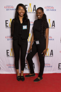 Two young ladies dressed business casual on red carpet